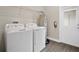 Functional laundry room with washer, dryer, water heater, and storage shelving, next to a door at 15060 Book Club Rd, Winter Garden, FL 34787