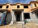 Unfinished townhome with block construction, prepped for finishes and featuring a covered entryway at 15345 Burgtheater Dr, Winter Garden, FL 34787