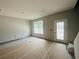 Unfinished living room featuring a large window, white walls, and flooring being prepared for installation at 15345 Burgtheater Dr, Winter Garden, FL 34787