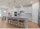 Bright, all-white kitchen with hardwood floors, stainless steel appliances, island with seating, and pendant lights at 1536 Groveline Rd, St Cloud, FL 34771