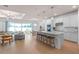 Modern, all-white kitchen with hardwood floors, stainless steel appliances, island, and pendant lighting at 1536 Groveline Rd, St Cloud, FL 34771