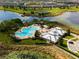 Aerial view of a community pool, clubhouse, and surrounding lakes and neighborhoods at 15477 Blackbead St, Winter Garden, FL 34787