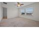 Bright bedroom featuring neutral carpet, ceiling fan, and sun-filled windows with neighborhood views at 15477 Blackbead St, Winter Garden, FL 34787