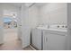 Clean laundry room with modern washer and dryer; adjacent to a bedroom with natural light at 15477 Blackbead St, Winter Garden, FL 34787