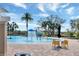 Community pool with a water feature, dining area, and lounge chairs under shady palm trees at 15477 Blackbead St, Winter Garden, FL 34787