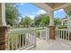 Covered porch with brick-based columns and white railing, offering a view of the quiet street at 15477 Blackbead St, Winter Garden, FL 34787