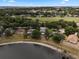Aerial view of a home next to pond surrounded by lush trees in a residential community at 1552 Whooping Dr, Groveland, FL 34736