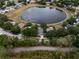 Aerial view of a home beside a serene pond, showcasing the surrounding community at 1552 Whooping Dr, Groveland, FL 34736