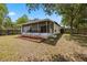 Backyard features a screened porch and patio seating, with a grassy lawn at 1552 Whooping Dr, Groveland, FL 34736