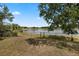 Backyard with a fence bordering a serene lake, offering privacy and scenic views at 1552 Whooping Dr, Groveland, FL 34736