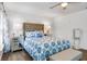 Bright bedroom with a decorative bed, mirrored nightstands, and wood-look flooring at 1552 Whooping Dr, Groveland, FL 34736