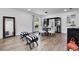 A dining area with an accent mirror and white upholstered chairs and table at 1552 Whooping Dr, Groveland, FL 34736