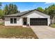 Charming single-story home featuring a two-car garage, fresh paint, and tidy landscaping at 1552 Whooping Dr, Groveland, FL 34736