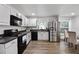 Bright kitchen with white cabinetry, stainless steel appliances, and modern black appliances at 1552 Whooping Dr, Groveland, FL 34736