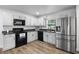 Bright kitchen with white cabinetry, stainless steel appliances, and modern sink at 1552 Whooping Dr, Groveland, FL 34736