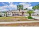 Charming single-story home with a vibrant red door and meticulously maintained landscaping showcasing curb appeal at 15628 Hidden Lake Cir, Clermont, FL 34711