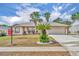 Inviting single-story home with a two-car garage and well-manicured landscaping featuring charming palm trees at 15628 Hidden Lake Cir, Clermont, FL 34711