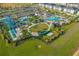 Stunning aerial view of community amenities, including a pool, playground, volleyball court, and lush landscaping at 1596 Moon Valley Dr, Davenport, FL 33896