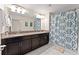 Bathroom showcasing double vanity, granite countertop, and decorative shower curtain at 1596 Moon Valley Dr, Davenport, FL 33896