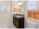 Compact bathroom features a dark vanity, granite countertop, and marble-style tile flooring at 1596 Moon Valley Dr, Davenport, FL 33896