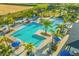 Aerial view of a community pool area with multiple pools, lounge seating, tropical foliage, and resort-style amenities at 1596 Moon Valley Dr, Davenport, FL 33896