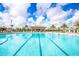 A large, sparkling community pool with ample seating, shaded lounge areas, and lush tropical landscaping at 1596 Moon Valley Dr, Davenport, FL 33896