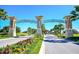 Grand entrance of ChampionsGate with manicured landscaping, colorful flower beds, and towering palm trees at 1596 Moon Valley Dr, Davenport, FL 33896