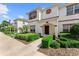Inviting townhouse with a well-kept lawn, featuring a bright, white exterior, brown trim, and covered entryway at 1596 Moon Valley Dr, Davenport, FL 33896