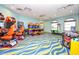 Bright game room featuring arcade games, vibrant carpet, and abundant natural light at 1596 Moon Valley Dr, Davenport, FL 33896