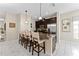 Modern kitchen island with granite countertops, dark cabinets, stainless steel appliances and bar stool seating at 1596 Moon Valley Dr, Davenport, FL 33896