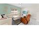 Cozy living room with a white sofa, leather recliner, and modern decor, bathed in natural light at 1596 Moon Valley Dr, Davenport, FL 33896