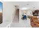 Bright living room with tile floors, staircase, dining area, and modern furnishings at 1596 Moon Valley Dr, Davenport, FL 33896