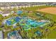 Thrilling aerial view of the community waterpark featuring twisting waterslides surrounded by palm trees at 1596 Moon Valley Dr, Davenport, FL 33896