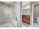 Bathroom with a glass door shower, marble tile surround, and double sink vanity at 17084 Harbor Oak Pkwy, Winter Garden, FL 34787
