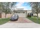 Front view of a house showing a two-car garage, a brick driveway, and a dark car at 17084 Harbor Oak Pkwy, Winter Garden, FL 34787