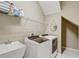 Functional laundry room with modern washer and dryer, sink, shelf storage, and bright lighting at 17084 Harbor Oak Pkwy, Winter Garden, FL 34787