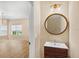 Stylish powder room features a wood vanity with a round mirror and modern light fixture at 1745 Indiana Ave # J, Winter Park, FL 32789