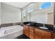 Bright bathroom features a soaking tub, dual-sink vanity with granite counters, and tile accents at 1745 Indiana Ave # J, Winter Park, FL 32789