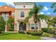 Inviting two-story townhouse featuring an arched entryway and lush tropical landscaping at 1745 Indiana Ave # J, Winter Park, FL 32789