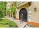 An inviting entrance with an arched double door, lush landscaping, and exterior lighting at 1745 Indiana Ave # J, Winter Park, FL 32789