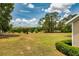 Spacious backyard with lush green lawn and mature trees, offering a serene and expansive outdoor space at 17631 Vista Belle Ct, Montverde, FL 34756