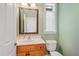 Traditional bathroom features a wood vanity, mirror and window at 17631 Vista Belle Ct, Montverde, FL 34756