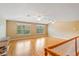 Expansive bonus room with hardwood floors, two windows, and neutral paint at 17631 Vista Belle Ct, Montverde, FL 34756