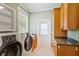 Bright laundry room with tile floors, washer, dryer, and storage cabinets at 17631 Vista Belle Ct, Montverde, FL 34756