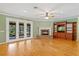 Comfortable living room with a brick fireplace, hardwood floors, and patio access at 17631 Vista Belle Ct, Montverde, FL 34756