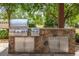Stone accented outdoor kitchen with stainless steel appliances at 17631 Vista Belle Ct, Montverde, FL 34756