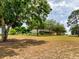 Expansive property with mature trees framing a charming single-story home with a welcoming front porch at 17631 Vista Belle Ct, Montverde, FL 34756
