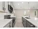 Bright kitchen featuring white countertops and backsplash, with gray cabinets and stainless steel appliances at 1915 Terrapin Rd, Ocoee, FL 34761