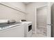 Bright laundry room featuring modern washer and dryer, with wire shelving for storage space and access to closet area at 1915 Terrapin Rd, Ocoee, FL 34761