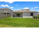 The backyard features a covered patio, well-manicured lawn, and view of the neighbor's house at 2388 Volunteer Ave, Kissimmee, FL 34744